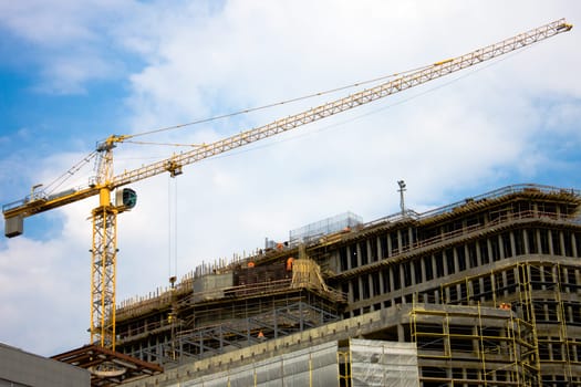 photo of the construction site with crane, building and workers