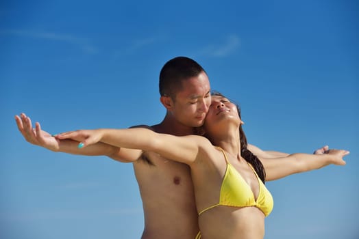 happy young asian couple enjoying summer and have on beautiful white sand beach