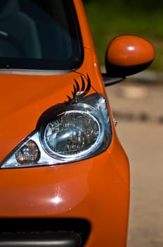 orange lady car with eyelash over front headlight