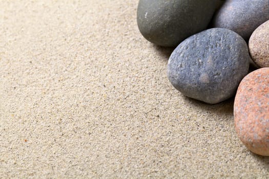 Pebble stones on sandy beach background. Sandy texture. Macro shot