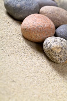 Pebble stones on sandy beach for background. Sand texture. Macro shot