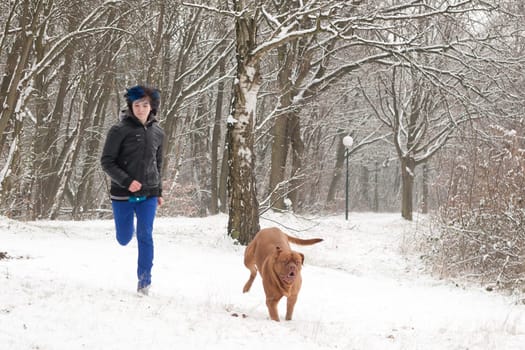 Funky boy is having fun with his dog in the snow