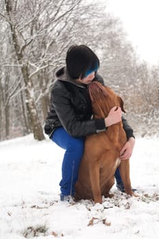 Funky boy is having fun with his dog in the snow