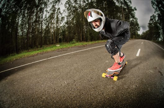 Downhill skateboarder in action on a asphalt road.