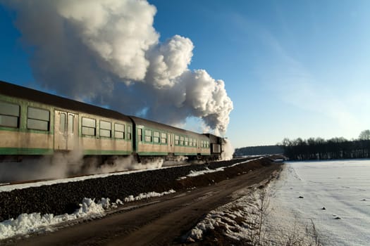Vintage steam train puffing through countryside during wintertime