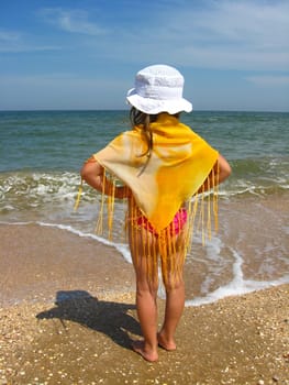 girl in bathing suit standing at the seacoast