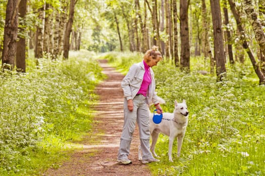 The woman walks with a dog in a wood