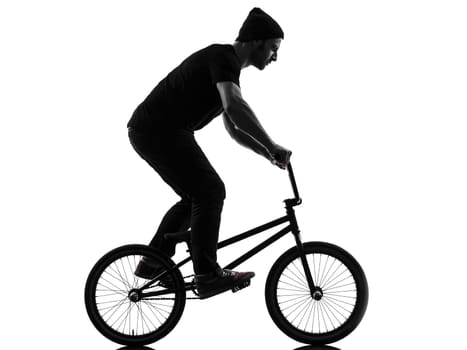 one caucasian man exercising bmx acrobatic figure in silhouette studio isolated on white background