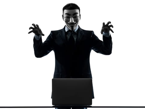 PARIS– OCTOBER 30 : one man dressed and masked as a  member of Anonymous underground group member computing computer menacing on October 30, 2012 in Paris ,France