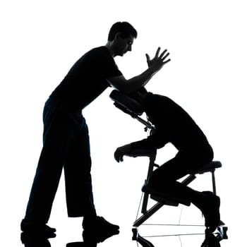 two men performing chair back massage in silhouette studio on white background