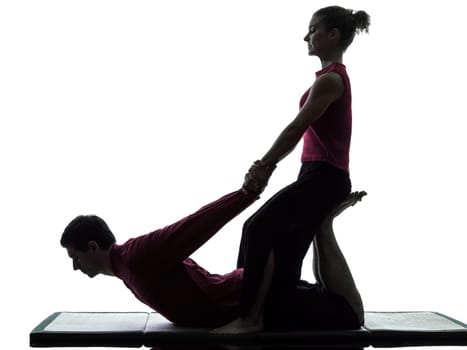 one man and woman performing thai massage in silhouette studio on white background