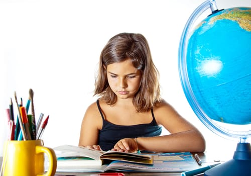 Little girl finishing her summer homework before going back to school. Isolated on white background with plenty of copyspace.