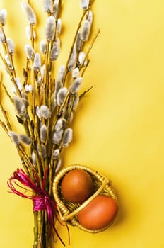 bunch of willow branches and two Easter eggs in basket