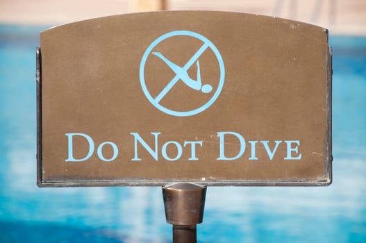 do not dive sign with blue water in background