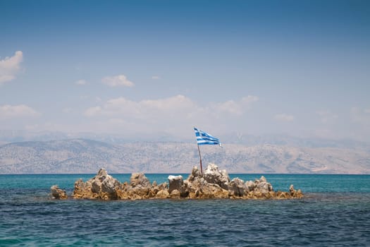 Greek flag on the rocky island near Corfu