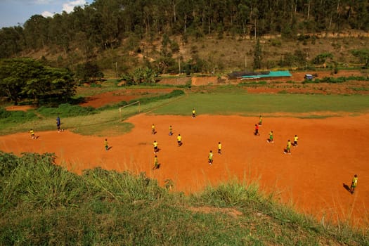 A group of African children, in Rwanda, Kigali, play soccer on a dirt field