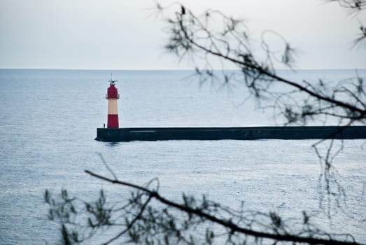 sea scape with red lighthouse and fisherman