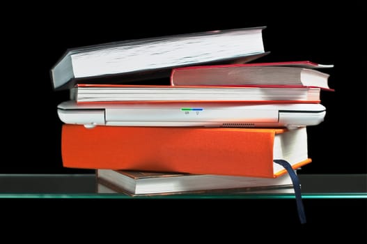 white laptop computer between books on the glass shelf
