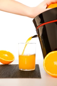 making orange juice from sliced oranges with help of juicer