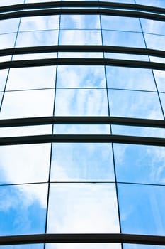 modern office building glass facade with reflection of sky