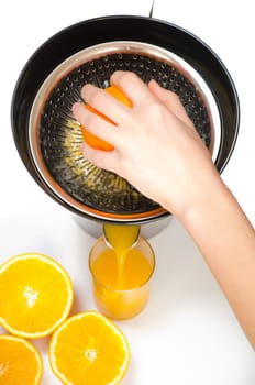 making orange juice from sliced oranges with help of jucier