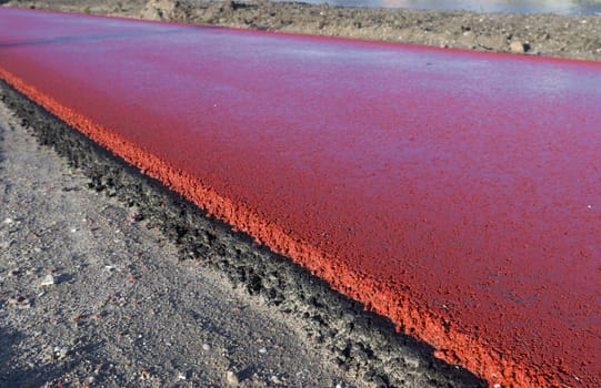 newly constructed bicycle lane made of red asphalt