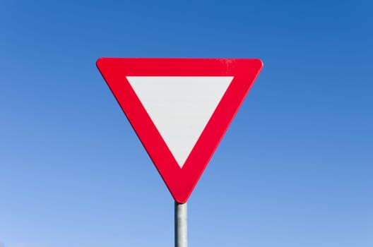 give way traffic sign against a clear blue sky