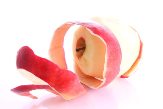 Red apple being peeled on a white background
