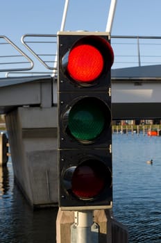 red color on a traffic light in front of a drawbridge