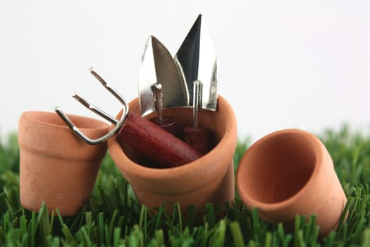 Clay pots on grass with garden tools