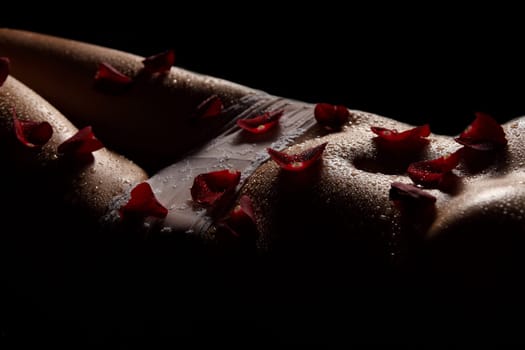 Photo shows the abdominal area covered with rose petals.