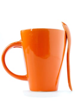 orange empty ceramic cup and spoon isolated on white