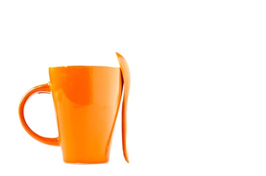 orange empty ceramic cup and spoon isolated on white