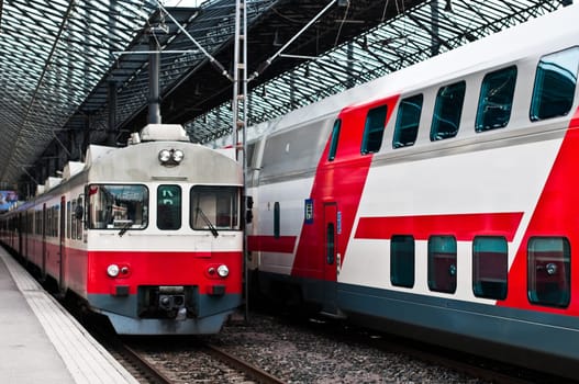 two trains in white and red color, one new and one old model at train station in Helsinki, Finland
