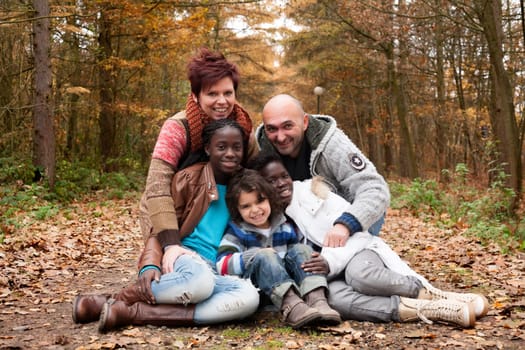 Happy family with foster children in the forest