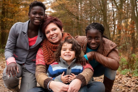 Happy family with foster children in the forest