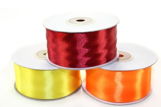 three rolls of ribbon against white background