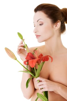 Portrait of beautiful adult woman with health skin and with red lily flower