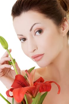 Portrait of beautiful adult woman with health skin and with red lily flower