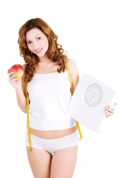 Attractive fit woman with scale and apple, isolated on white