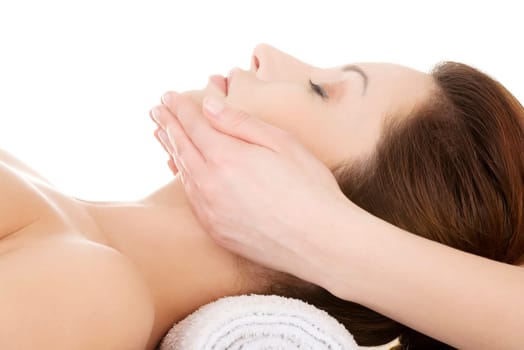 Beautiful young relaxed woman enjoy receiving face massage at spa saloon