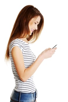 Young smiling caucasian tenn using cell phone, isolated on white.