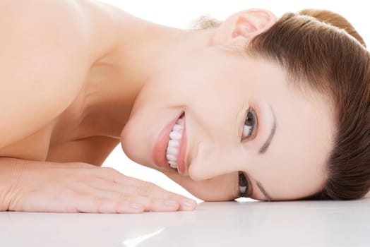 Sexy fit naked woman with healthy clean skin lying down, isolated on white