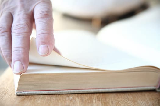 a man turns the pages of a large book