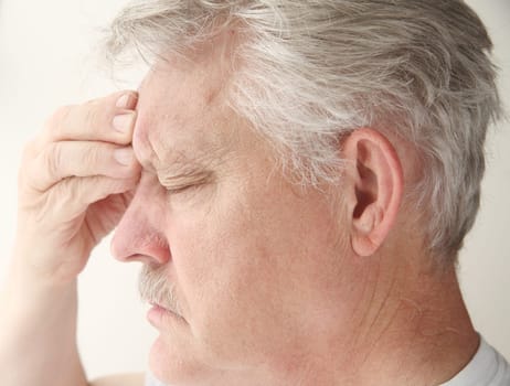 senior suffering from a bad headache centered near his eye