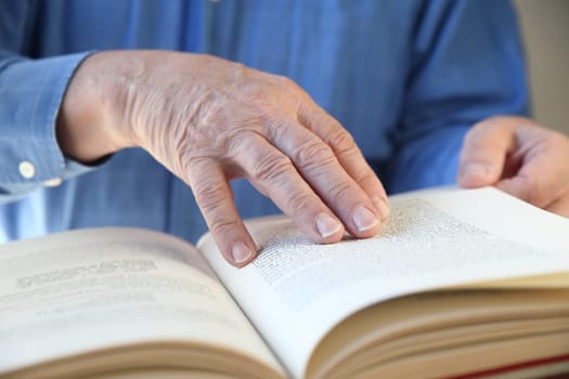 a senior man's hands on a book
