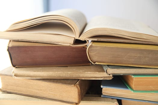 piles of old books with one open
