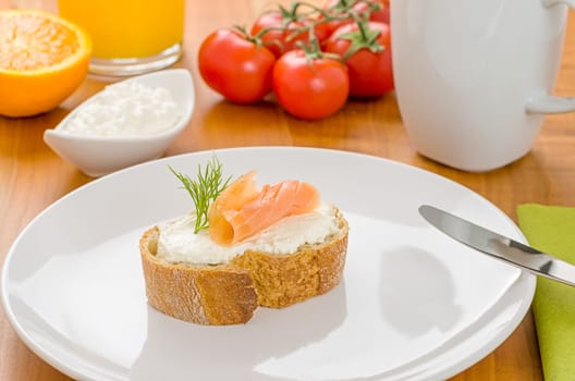 Baguette with salmon on a laid breakfast table