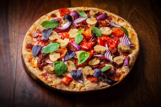 Homemade pizza with dried tomatoes, salami and basil