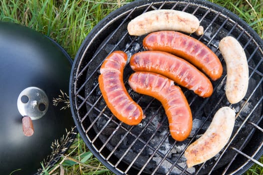 Grilled sliced sausages, outdoor barbecue in nature